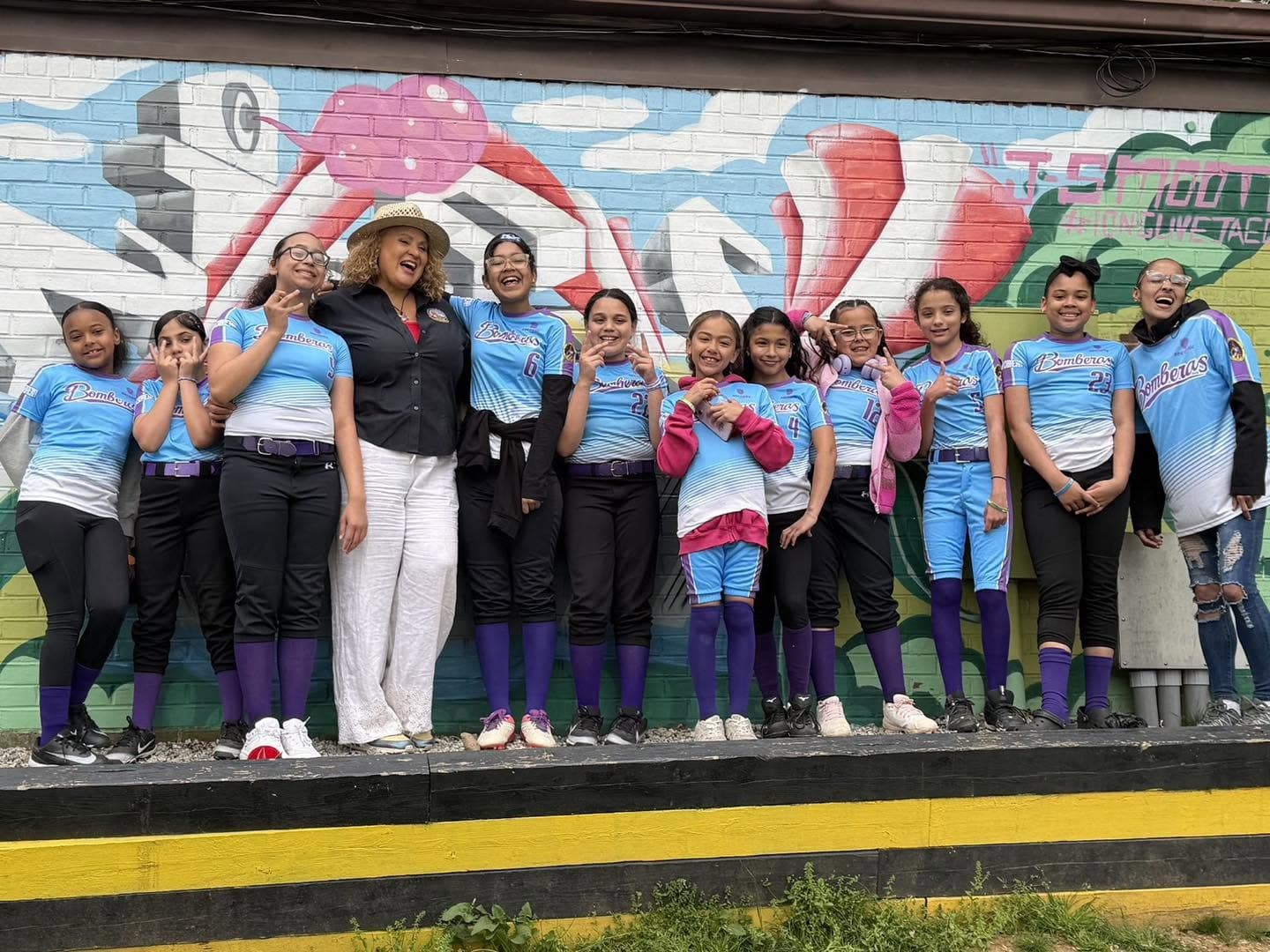 Bomberas softball team and coaches gathered at a community field